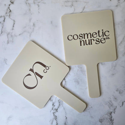 Square handheld mirror in nude acrylic with brown logo for cosmetic nurses customised with logo made in australia