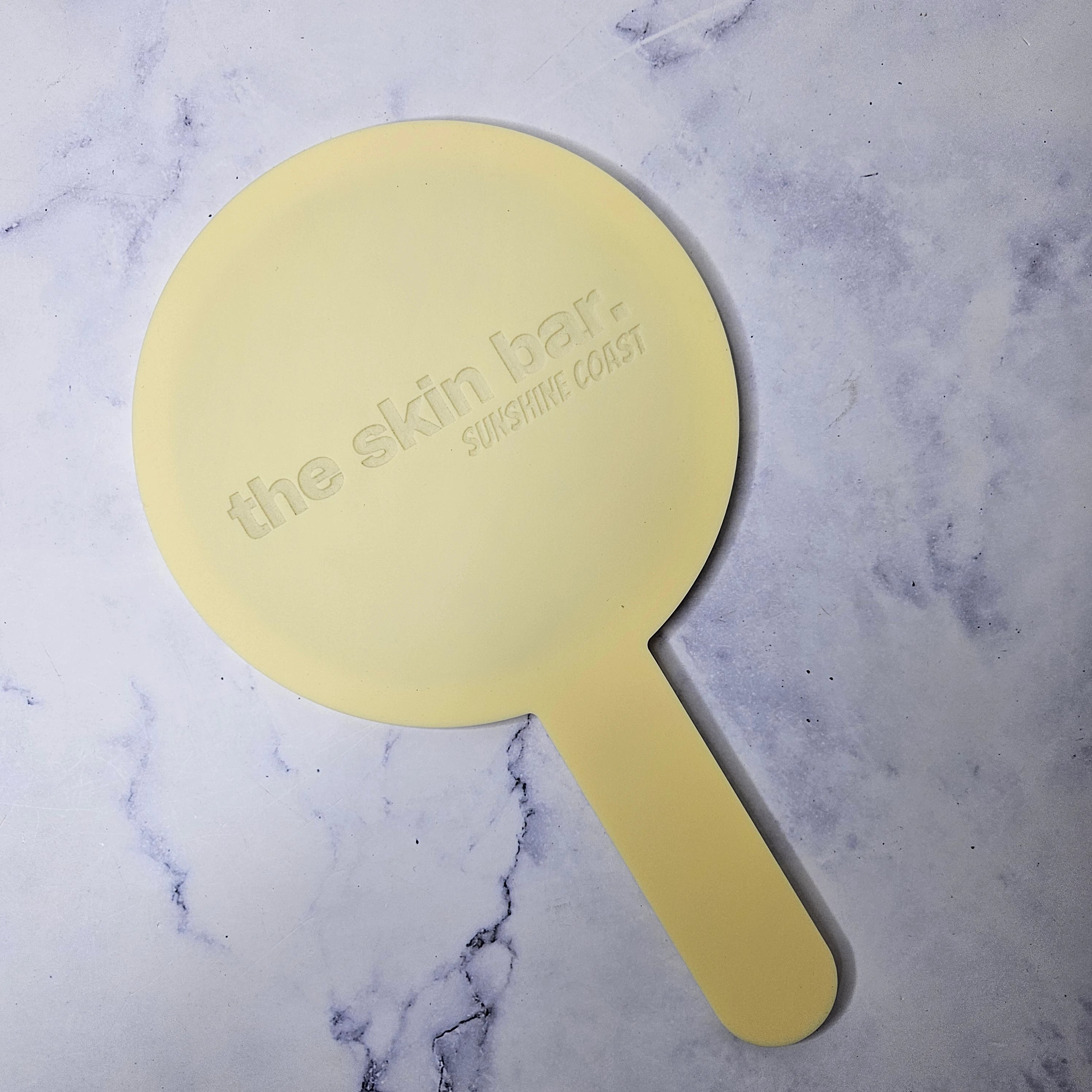 Round Handheld Mirror in Pastel Yellow with engraved logo, no colour