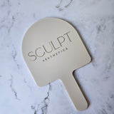 Custom Handheld Mirror with Logo for Injectable Clinic - Arch handheld mirror in beige acrylic with Gold logo