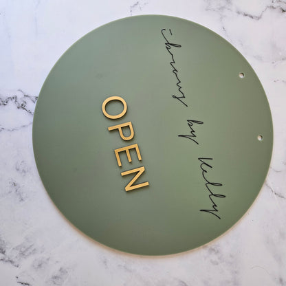 Round Open Sign in Olive Acrylic and Black Logo and Gold Writing