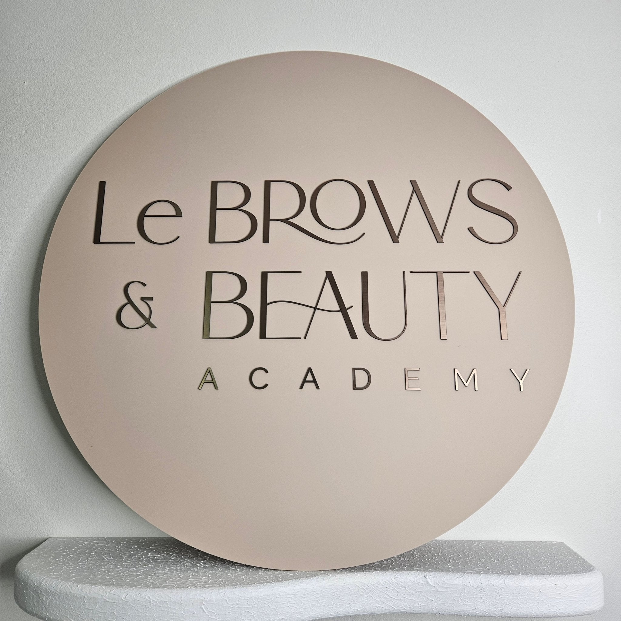 Round business sign with brushed brown acrylic letters