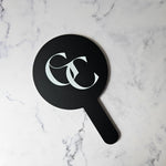 Round Handheld Mirror in Black Acrylic with White Logo