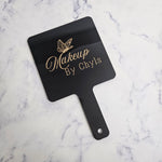 Gloss black hand held mirror in square shape with gold logo