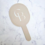 Oval handheld mirror in mushroom acrylic and white logo