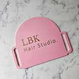 Pink hand held mirror in arch shape for hair salons